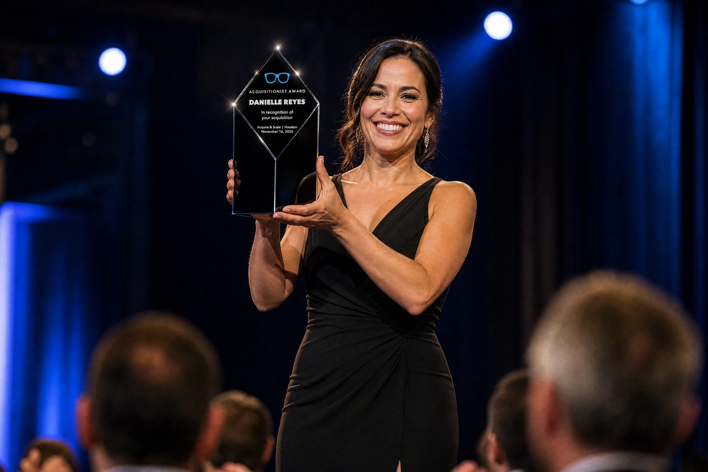 Illustration of a winner holding up the black crystal Acquisitionist Award on stage
